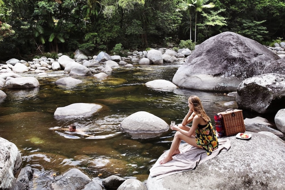 Woman enjoying the scenery around a waterhole at Mossman Gorge © Tourism Australia